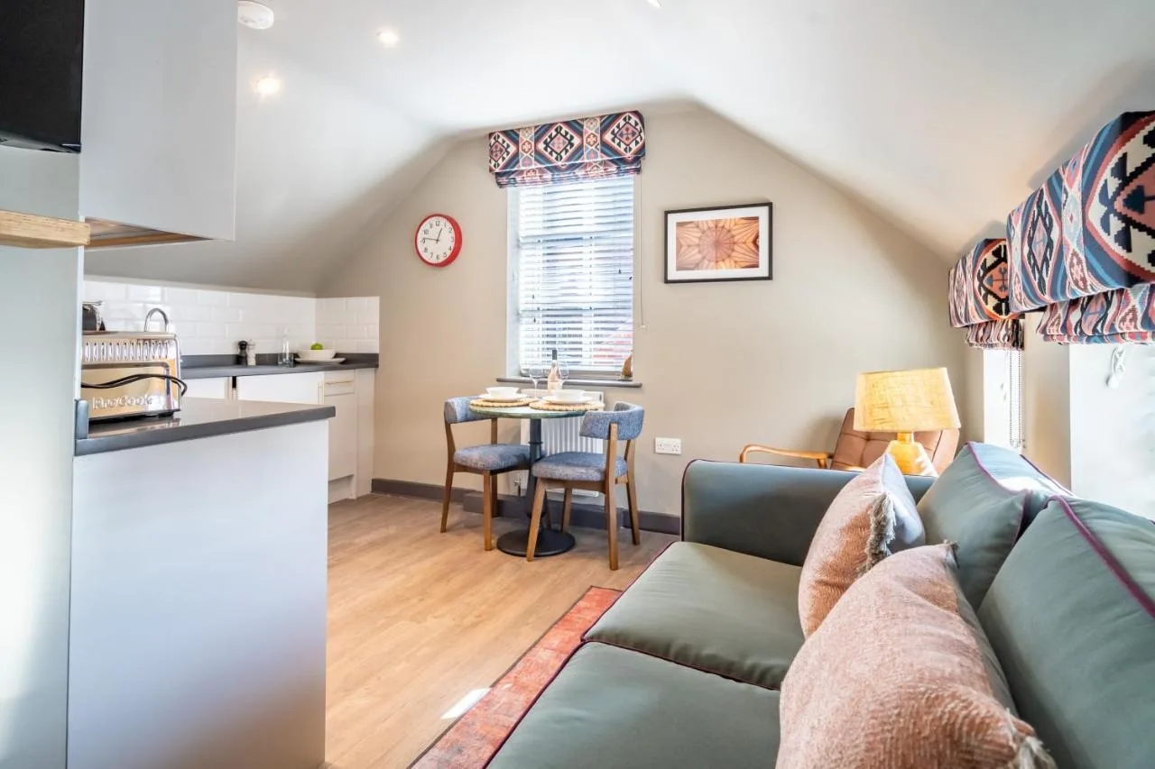 a living room with a couch and a kitchen at The Falcon in York