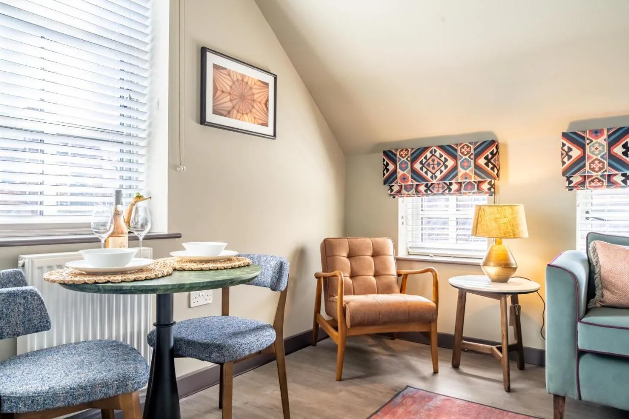 a living room with chairs and a table and a window at The Falcon in York