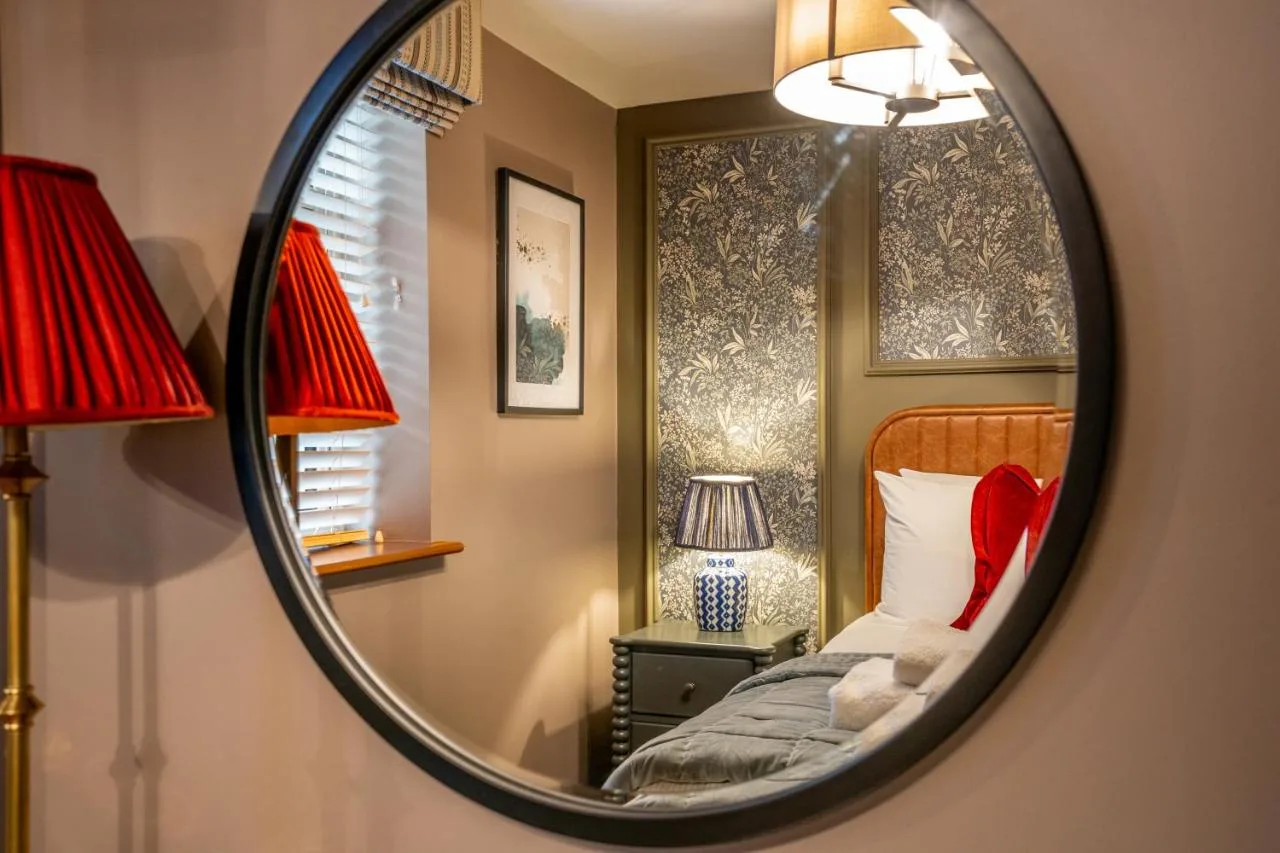 a bedroom with a bed and a mirror at The Falcon in York